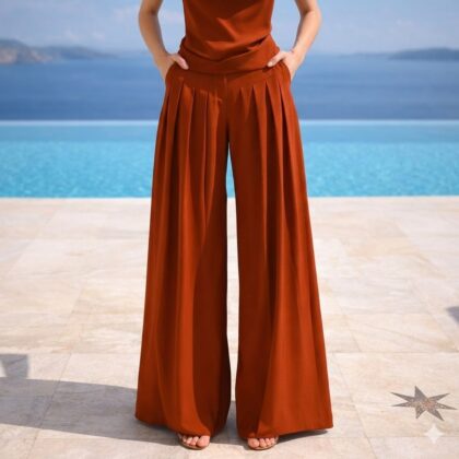Χειροποίητη Terracotta Pieta Palazzo Pants από βισκόζ με ψηλή μέση, πιέτες και ζώνη από το ίδιο ύφασμα. Κομψή palazzo παντελόνα σε terracotta απόχρωση με ρευστή κίνηση για minimal resort και καλοκαιρινά looks.