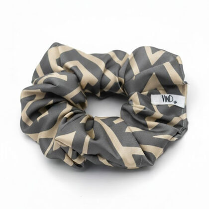 LIVIA GREY LATTE εμπριμέ σατέν scrunchie (λαστιχάκι μαλλιών) με geometric lines pattern σε grey και latte αποχρώσεις. Minimal και κομψό αξεσουάρ μαλλιών με απαλή υφή και σταθερό κράτημα.