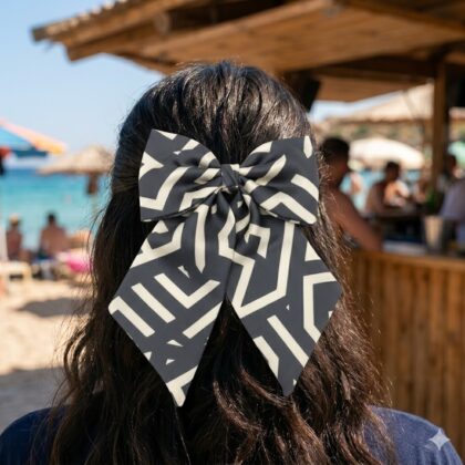 LIVIA GREY LATTE εμπριμέ φιόγκος μαλλιών από σατέν με geometric lines pattern σε grey και latte αποχρώσεις. Διαθέτει μπαρέτα για εύκολη εφαρμογή και σταθερό κράτημα. Minimal και κομψό αξεσουάρ μαλλιών για καθημερινά looks.