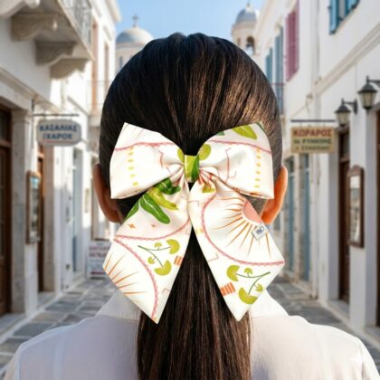 MARBELA εμπριμέ φιόγκος μαλλιών από σατέν με tropical pattern από φοίνικες και φλαμίνγκο σε σομόν και πράσινες αποχρώσεις. Διαθέτει μπαρέτα για εύκολη εφαρμογή και σταθερό κράτημα. Καλοκαιρινό τροπικό αξεσουάρ μαλλιών για κομψά looks.
